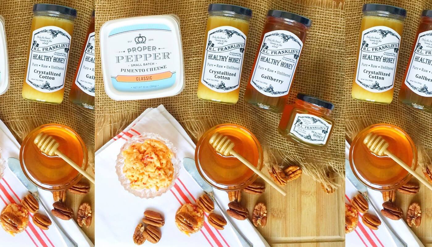 Variety of honey jars and honeycombs artfully arranged on a wooden table.