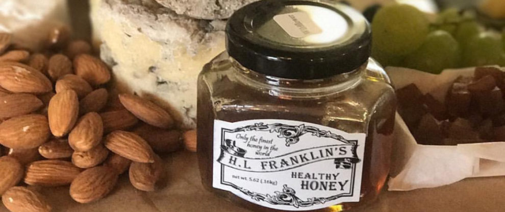 A jar of almond butter surrounded by almonds and bread slices.
