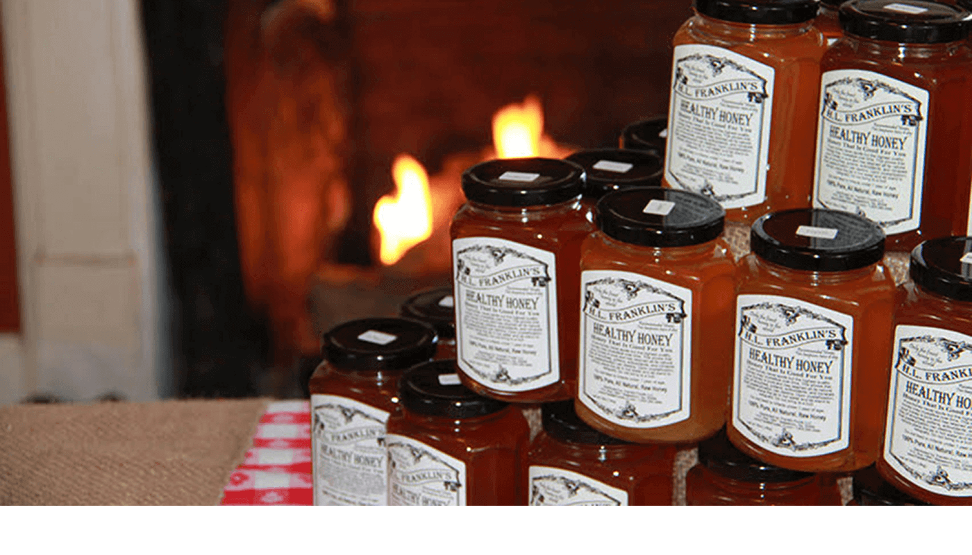 Jars of homemade preserves stacked near a cozy fireplace.